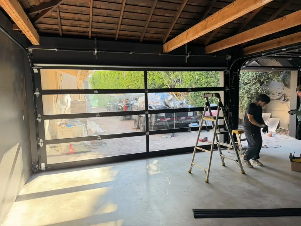 Glass garage door being installed inside a garage