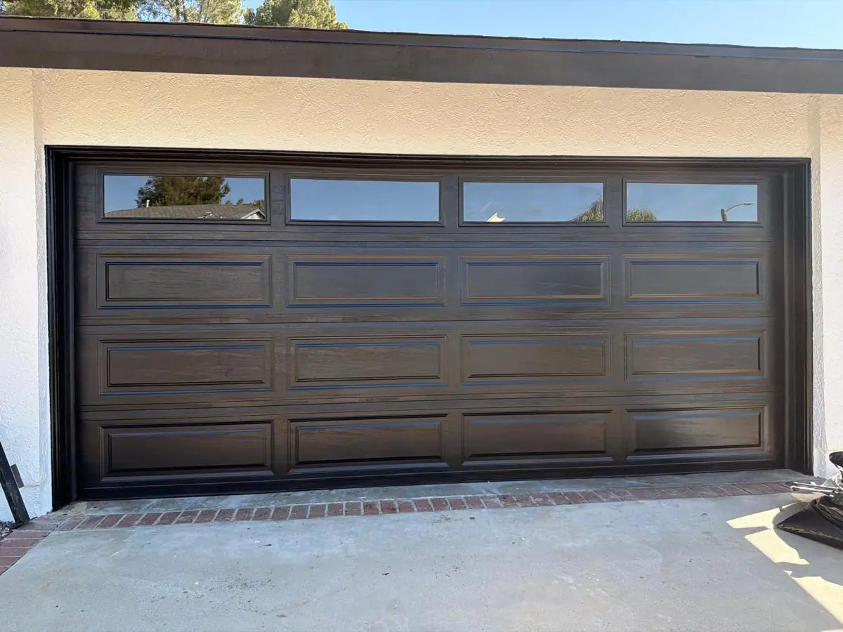 Dark brown carriage-style garage door with windows