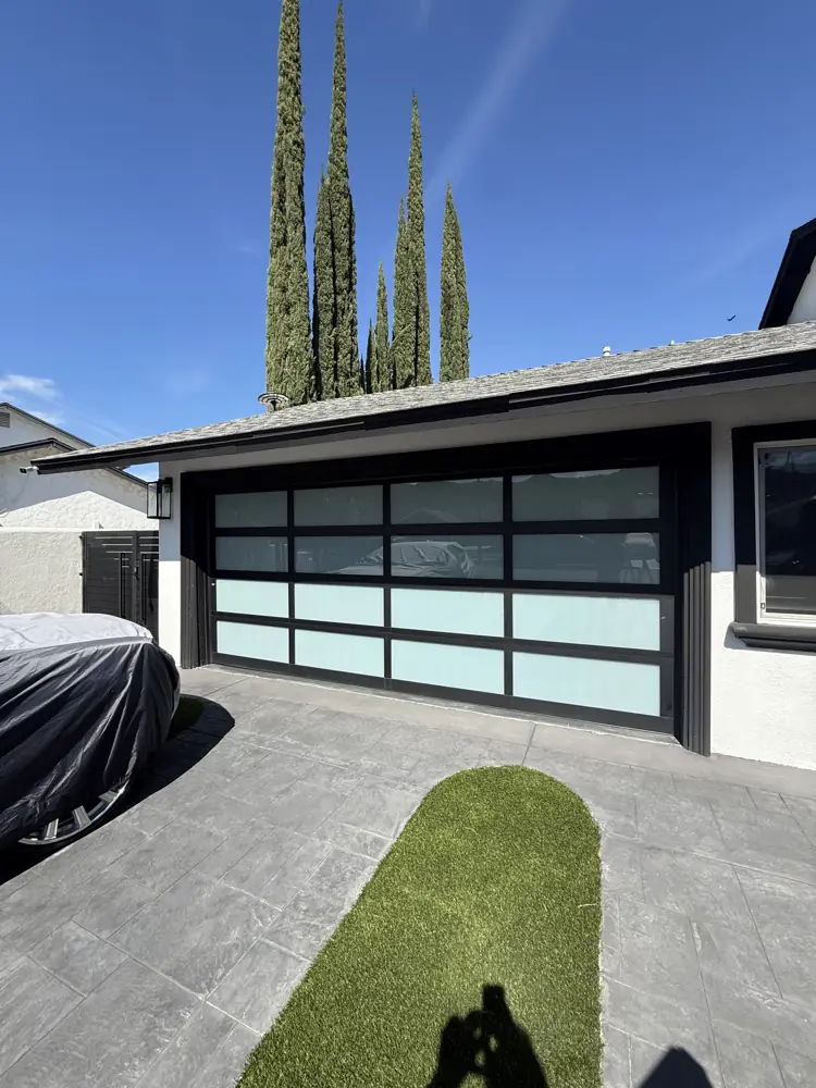 Black full-view glass garage door with frosted panels