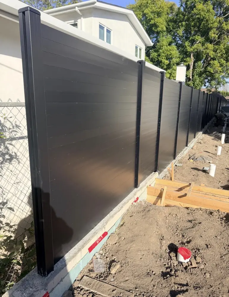 Black aluminum privacy fence along a property line