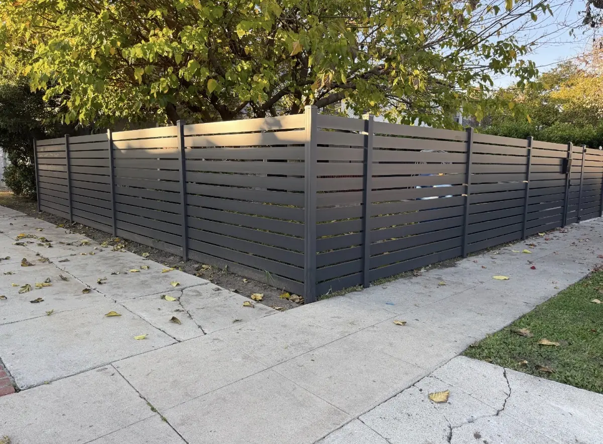 Black horizontal-slat fence along a street corner