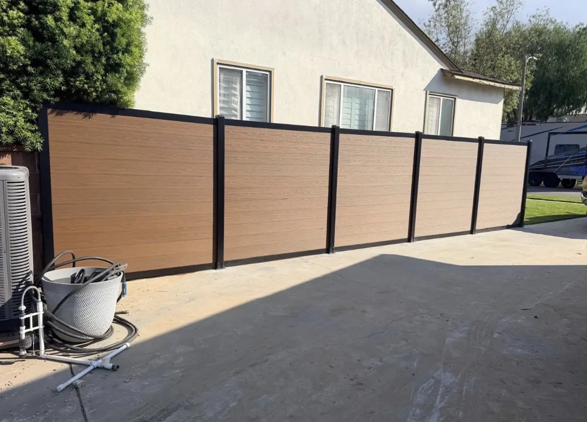 Wood-tone composite fence with black posts