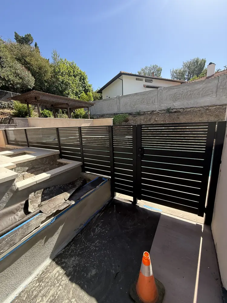 Black horizontal-slat fence on a hillside