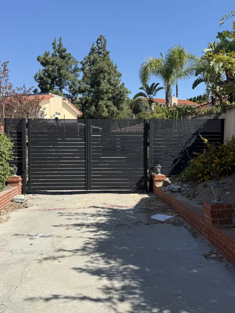 Black horizontal-bar driveway gate and fence