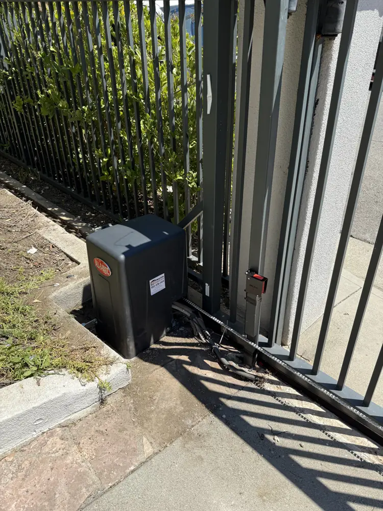 Sliding gate operator on a black steel gate