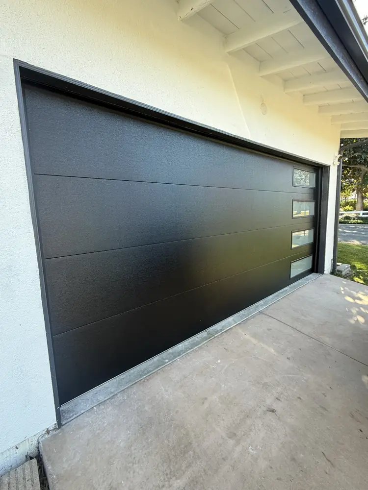 Black flush garage door on a white stucco home