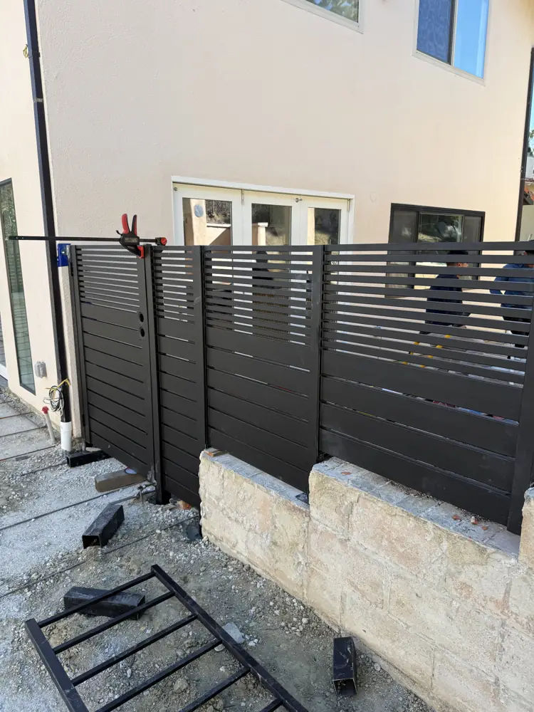 Black horizontal fence on a block wall