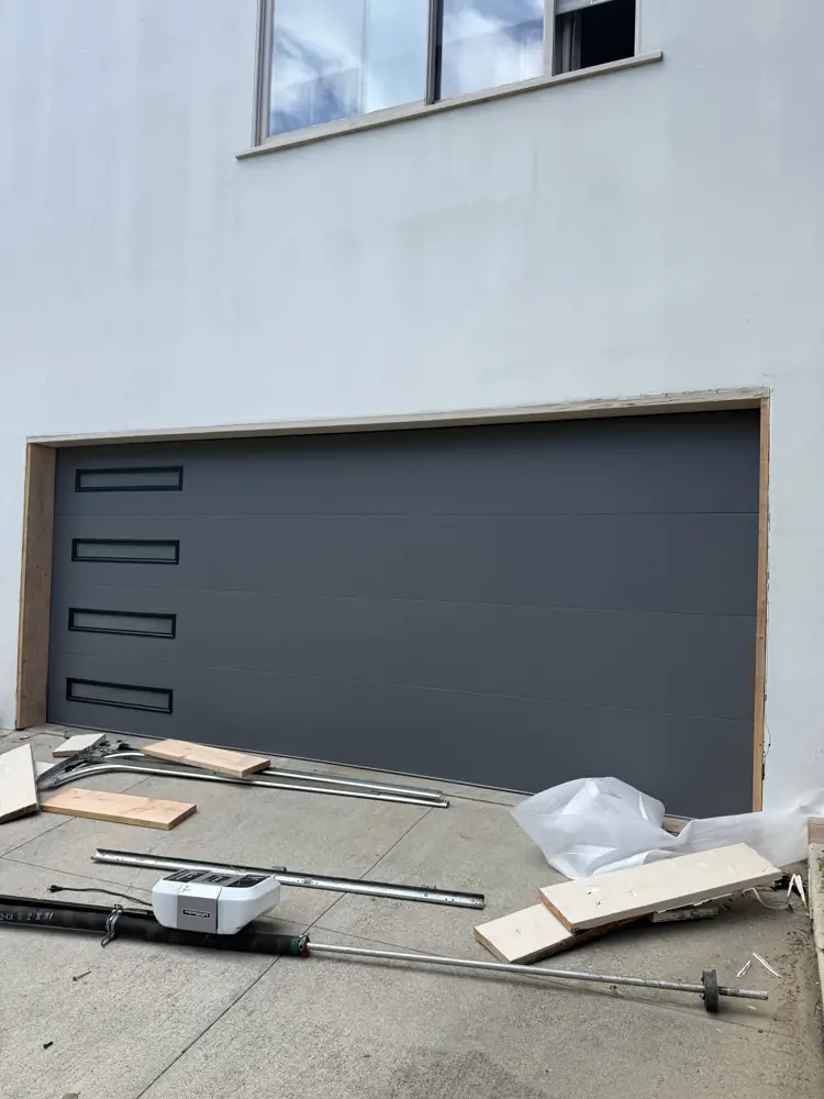 Charcoal modern garage door being installed