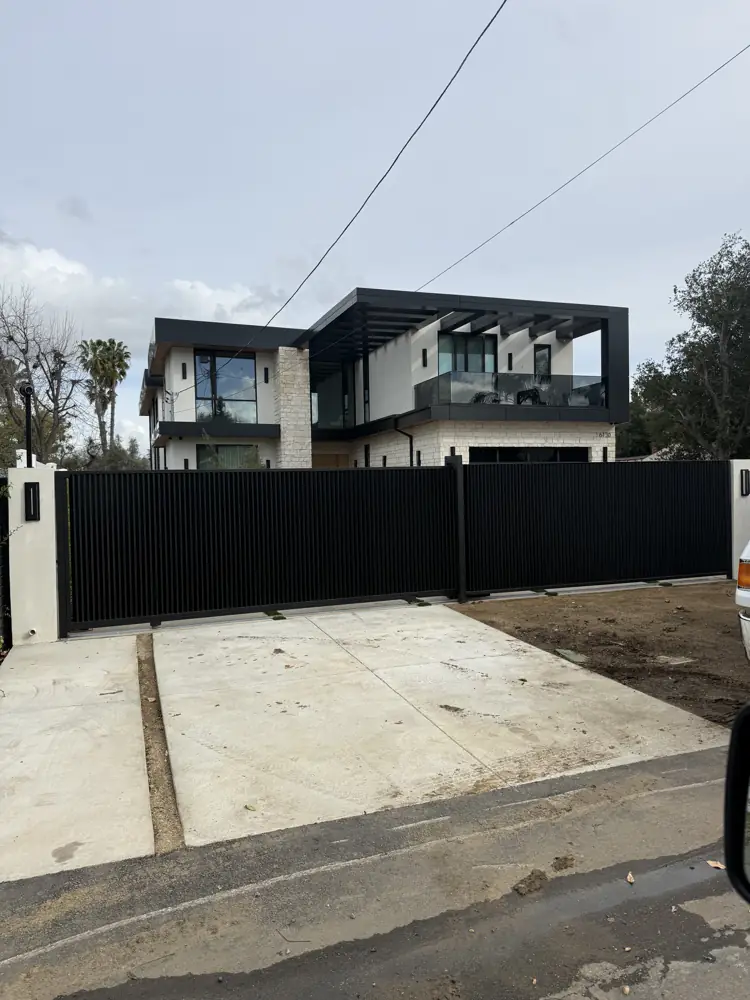 Black sliding driveway gate at a modern home
