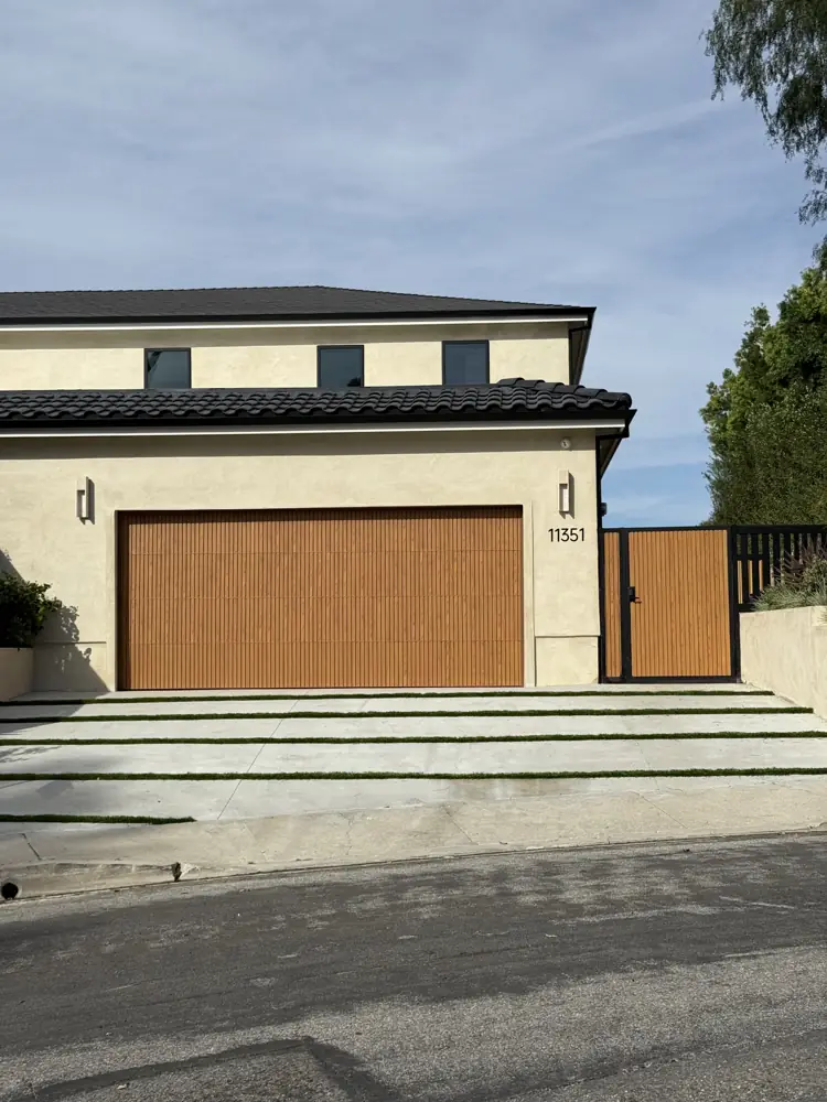 Wood-look garage door on a two-story stucco home