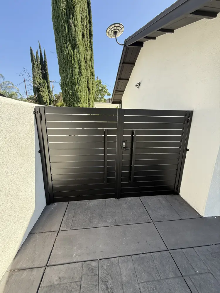 Black horizontal-slat side gate between walls