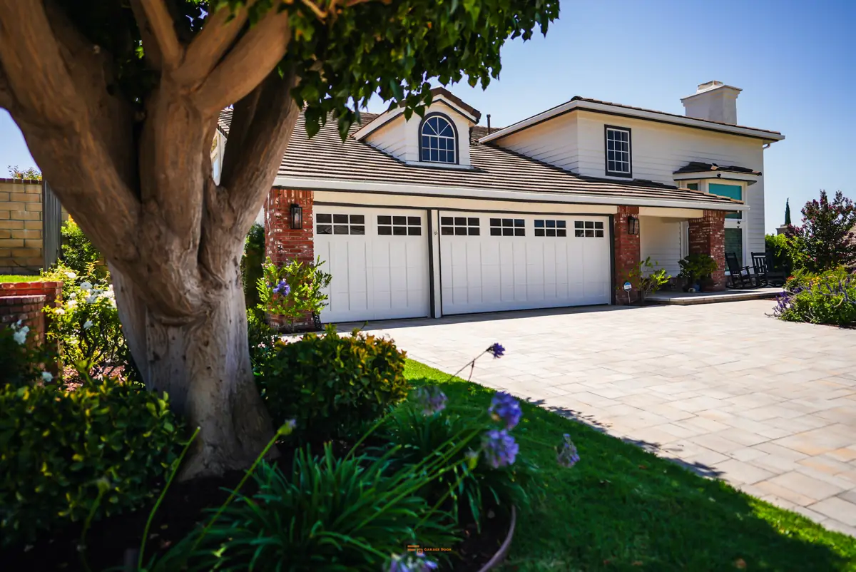 Three white garage doors on a large home