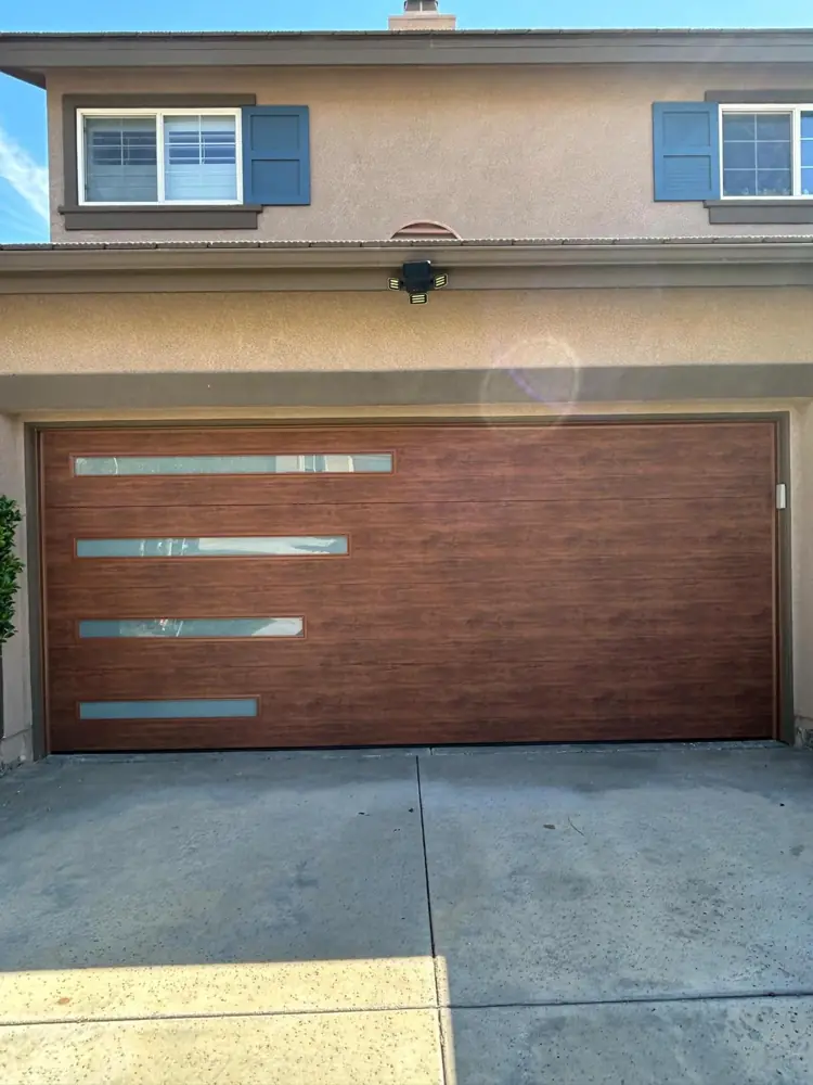Wood-tone modern garage door with window strips