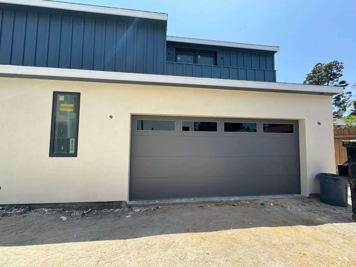 Charcoal garage door with top windows on a new home