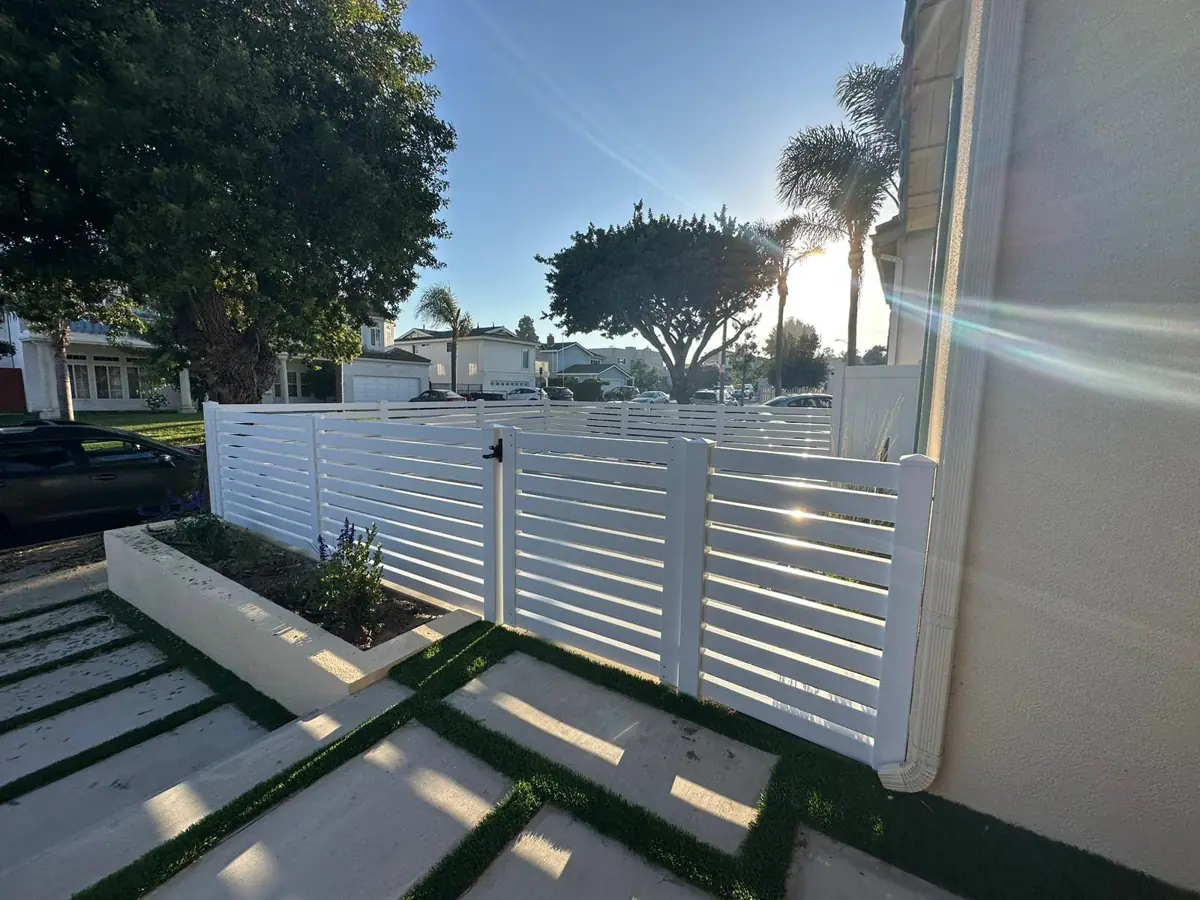 White horizontal fence and gate along a modern walkway