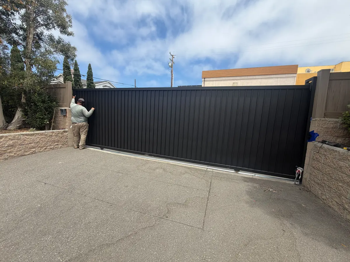 Technician with a new black sliding driveway gate